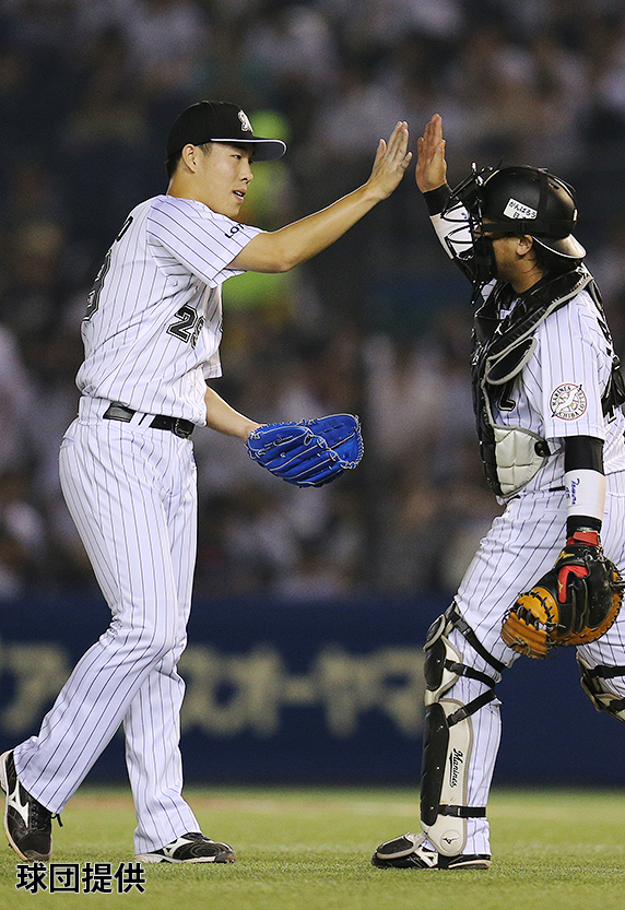 田村選手と勝利の八タッチを交わす西野投手